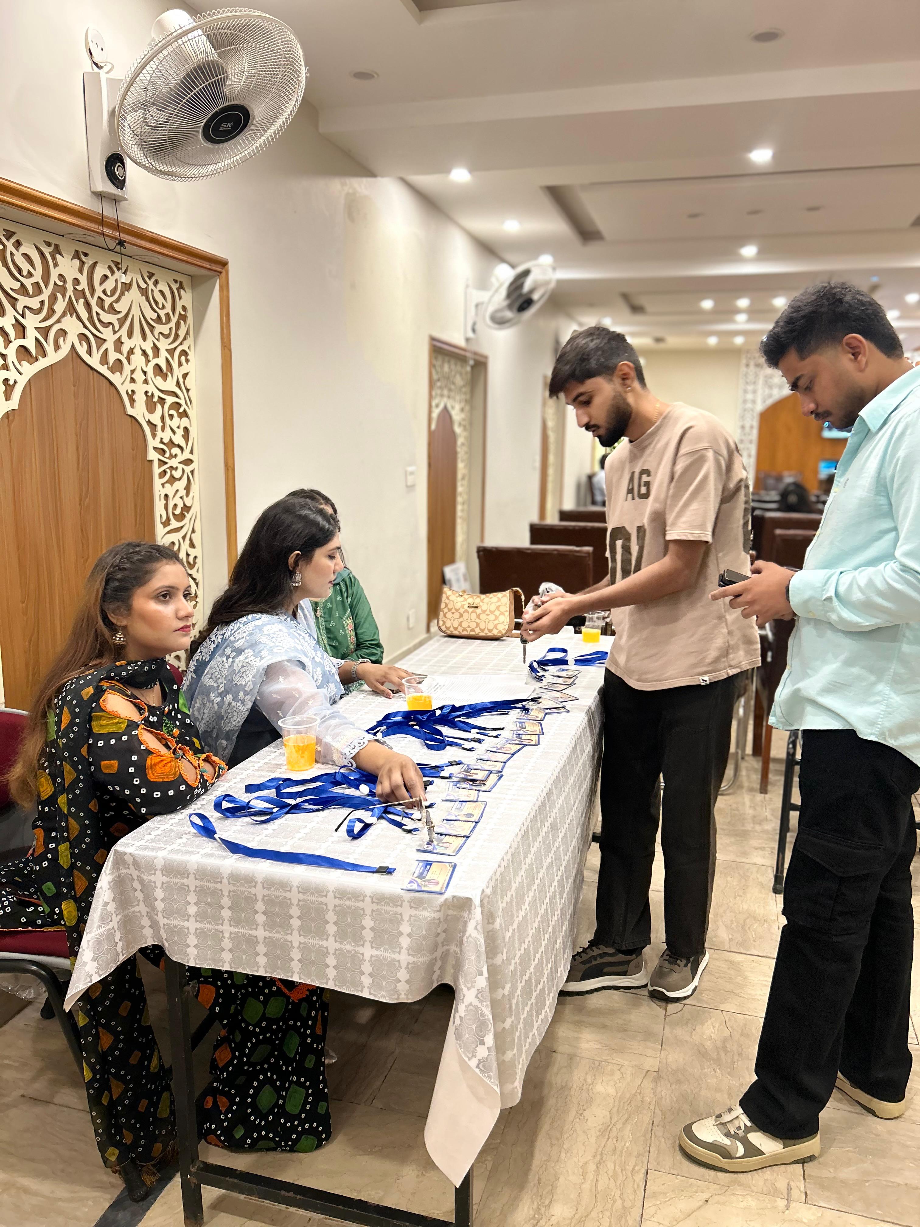 Students picking up name badges at registration for the Lahore Campus orientation